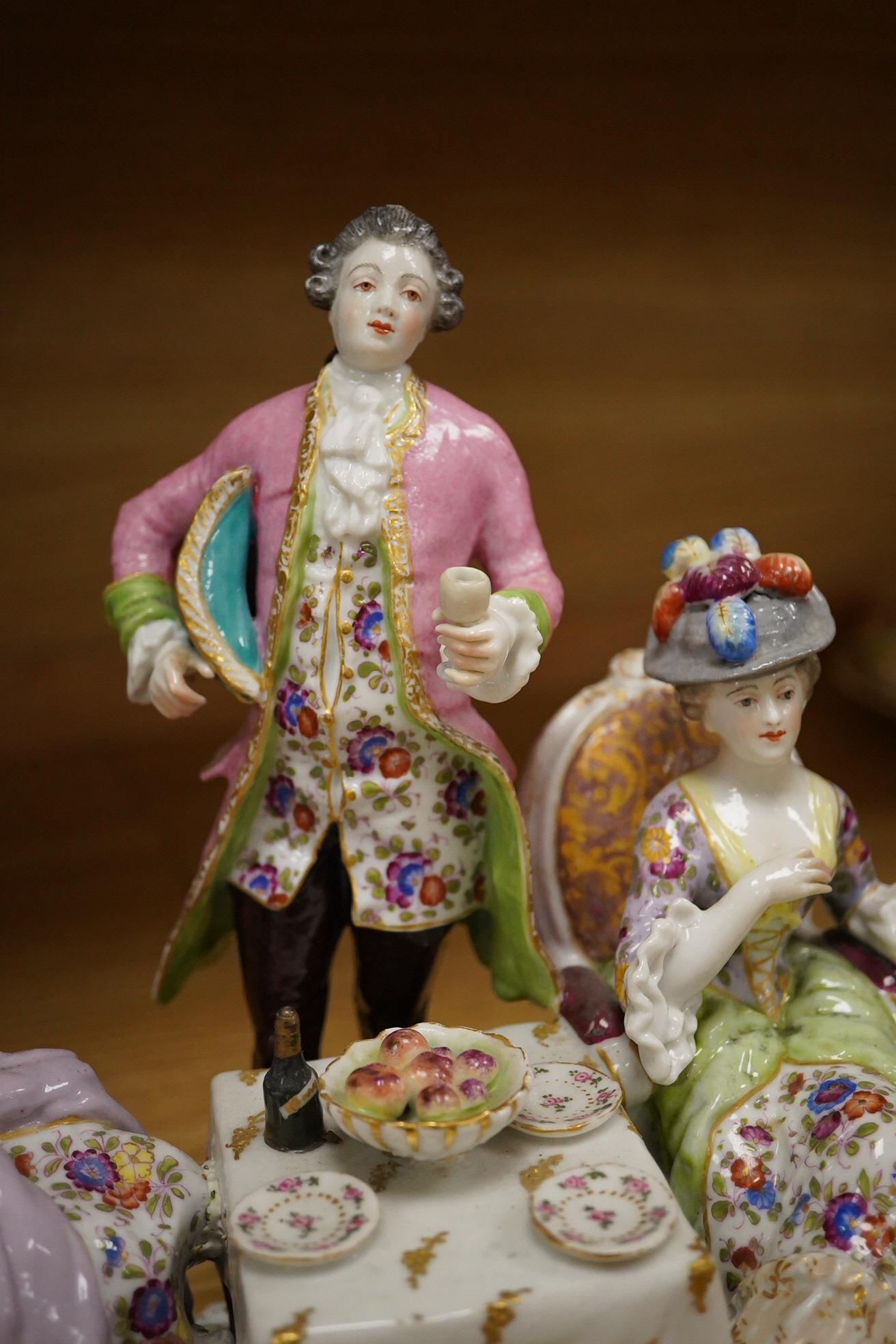 A 19th century Dresden porcelain group of three figures at a table, 24cm high